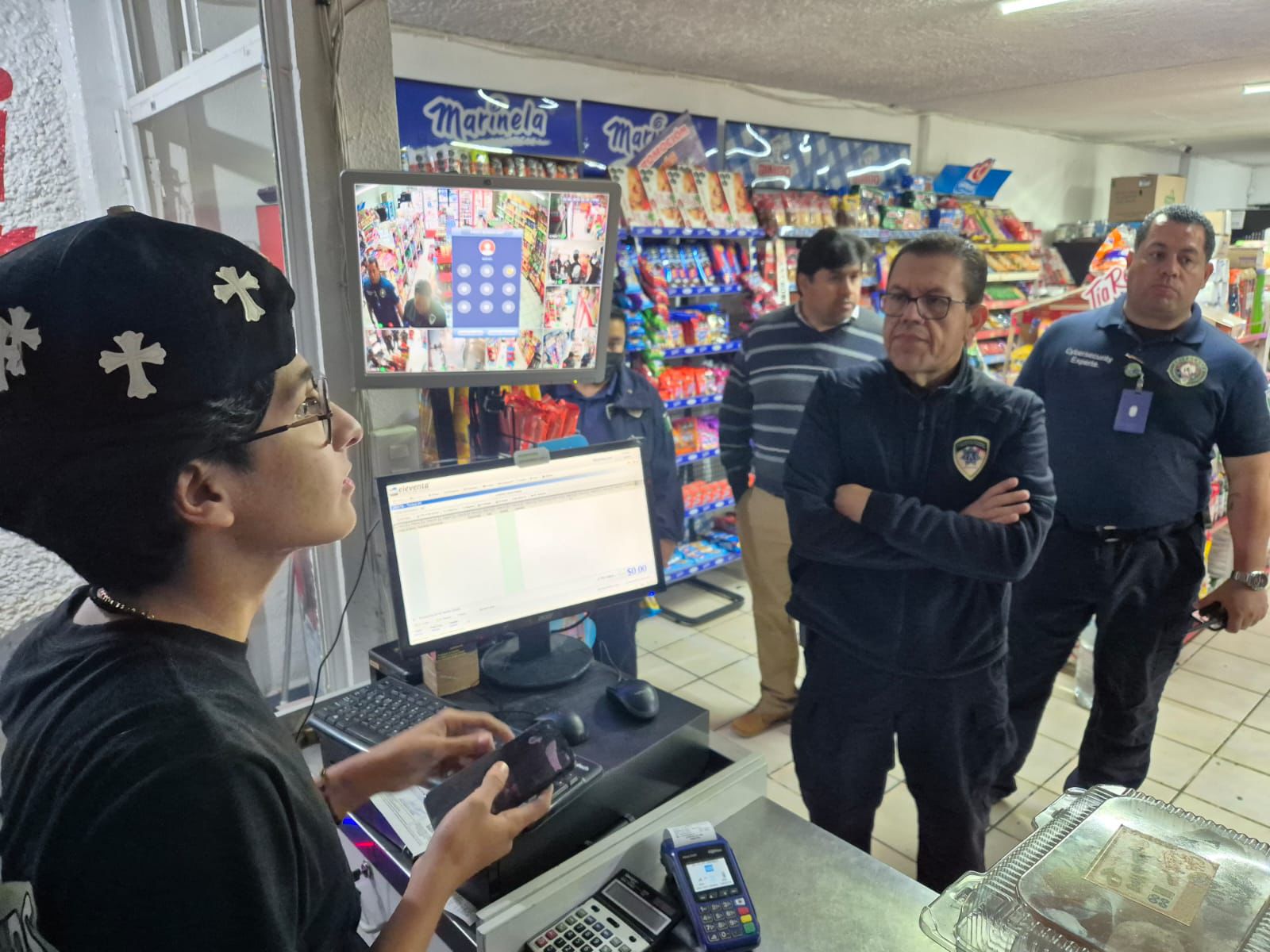 Fotografía del secretario de seguridad platicando con el dueño de un negocio